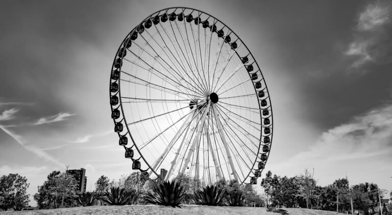 Striking black and white photo of a Ferris wheel in Puebla, Mexico, with a dramatic sky.